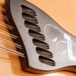 Close up view of the Buscarino 14 string guitar headstock featuring the builder logo inlay.