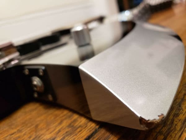 Close-up of a ding on the Cort Gene Simmons Axe Bass, showcasing play wear.