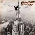 David Bromberg Wanted Dead or Alive Album Cover featuring a sepia toned image of David Bromberg against a rustic backdrop, hinting at the album's old west themes and musical eclecticism.