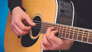 Guitarist testing acoustic guitar strings for review