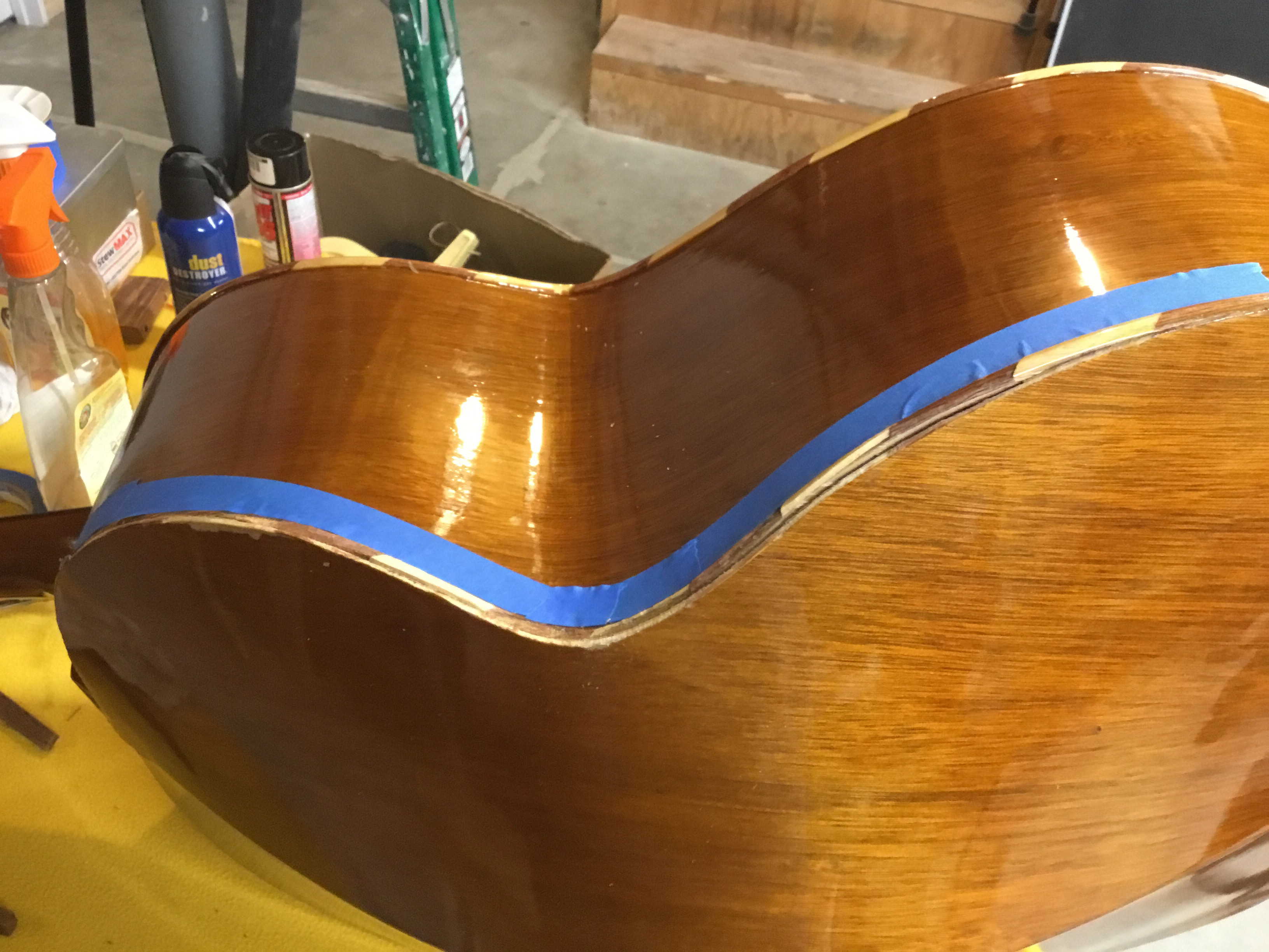 Close-up of razors and chisels carefully working on the damaged binding of the Guitarron