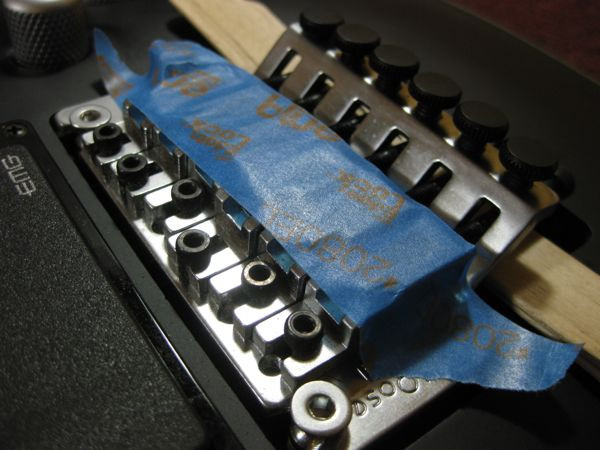 Painter's tape securing Floyd Rose string blocks to prevent loss during maintenance