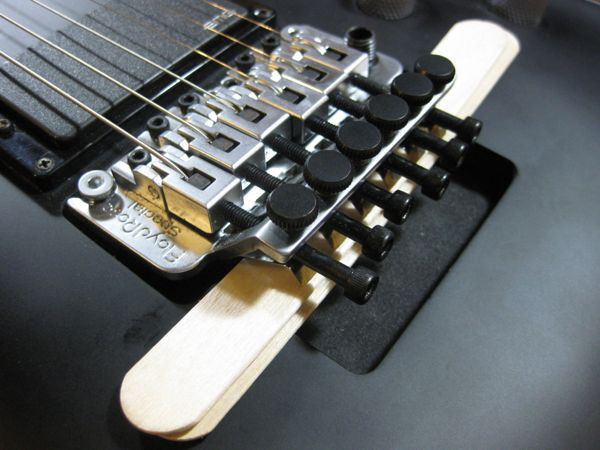 Popsicle sticks used to prop up a Floyd Rose bridge for easy string changes
