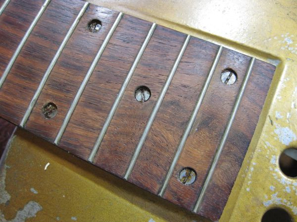 Close-up of removed ivory dot inlays from the vintage resonator guitar