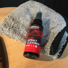 Applying lemon oil to a rosewood fretboard of an acoustic guitar for conditioning.