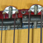 Close-up of a 1952 Precision Bass bridge plate showing the serial number and date.