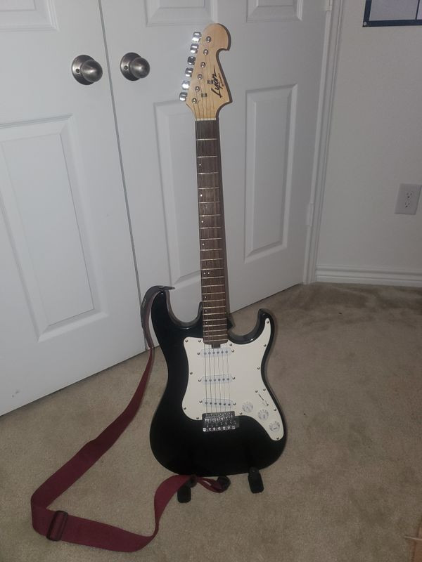 Lyon by Washburn Strat style electric guitar in player's lap, showcasing its sunburst finish and classic body shape