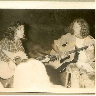 David Weiss and Gordy Wallace playing guitars at a Camp Fuller Council Fire, showcasing the musical atmosphere