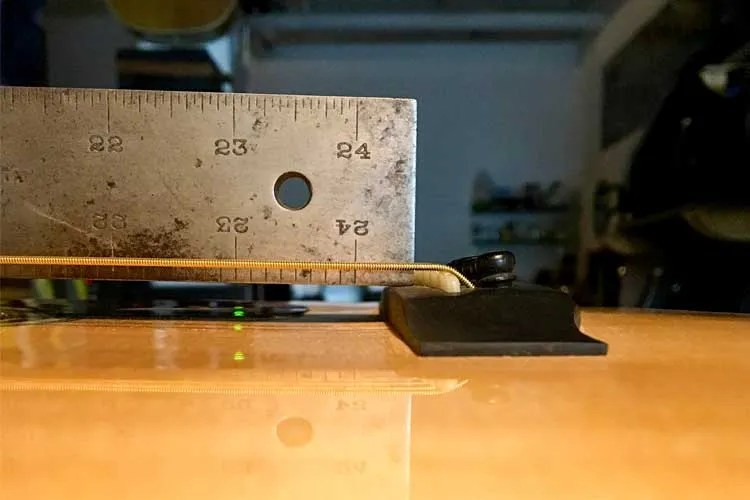 Image comparing a good neck angle and a bad neck angle on acoustic guitars using straightedges for visual demonstration.