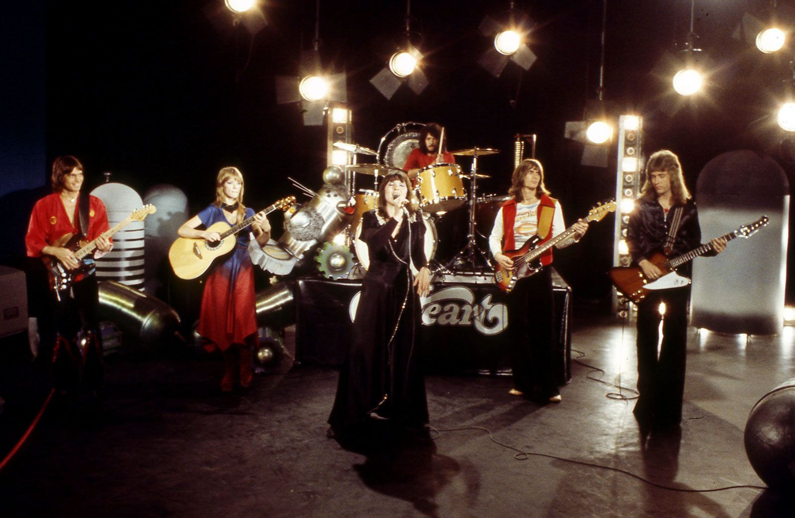 Heart performing in 1977, showcasing Nancy Wilson's guitar prowess and Ann Wilson's powerful vocals, defining their heart-driven rock sound.