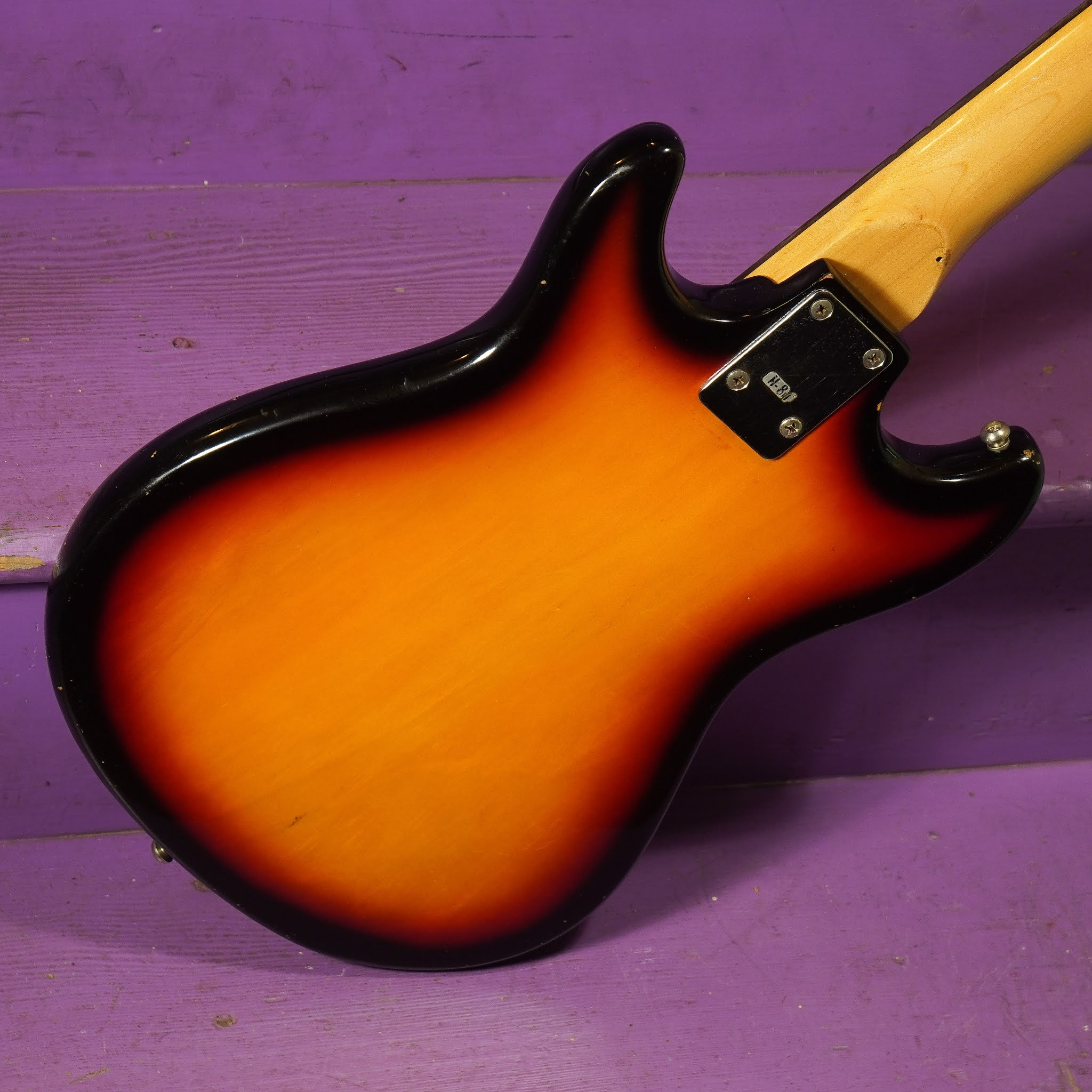 Close up of the guitar bridge and strings, showing the compensation adjustments made for modern string gauges.