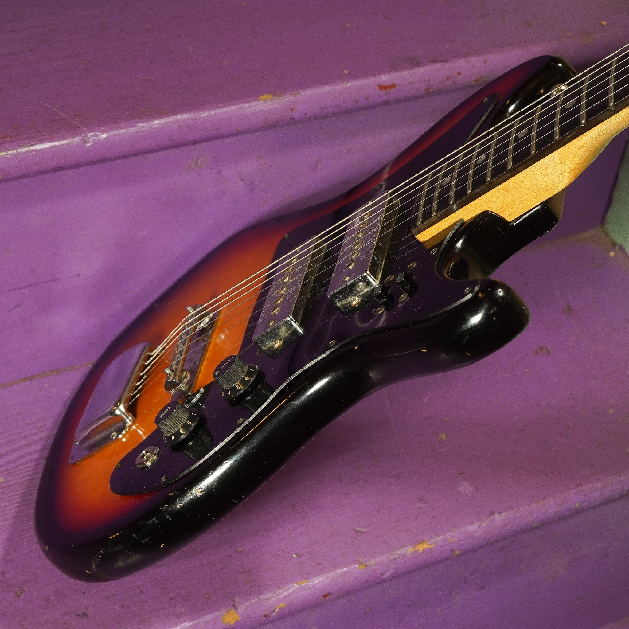 Image detailing the guitar's control knobs and pickguard, highlighting the vintage hardware and design elements.