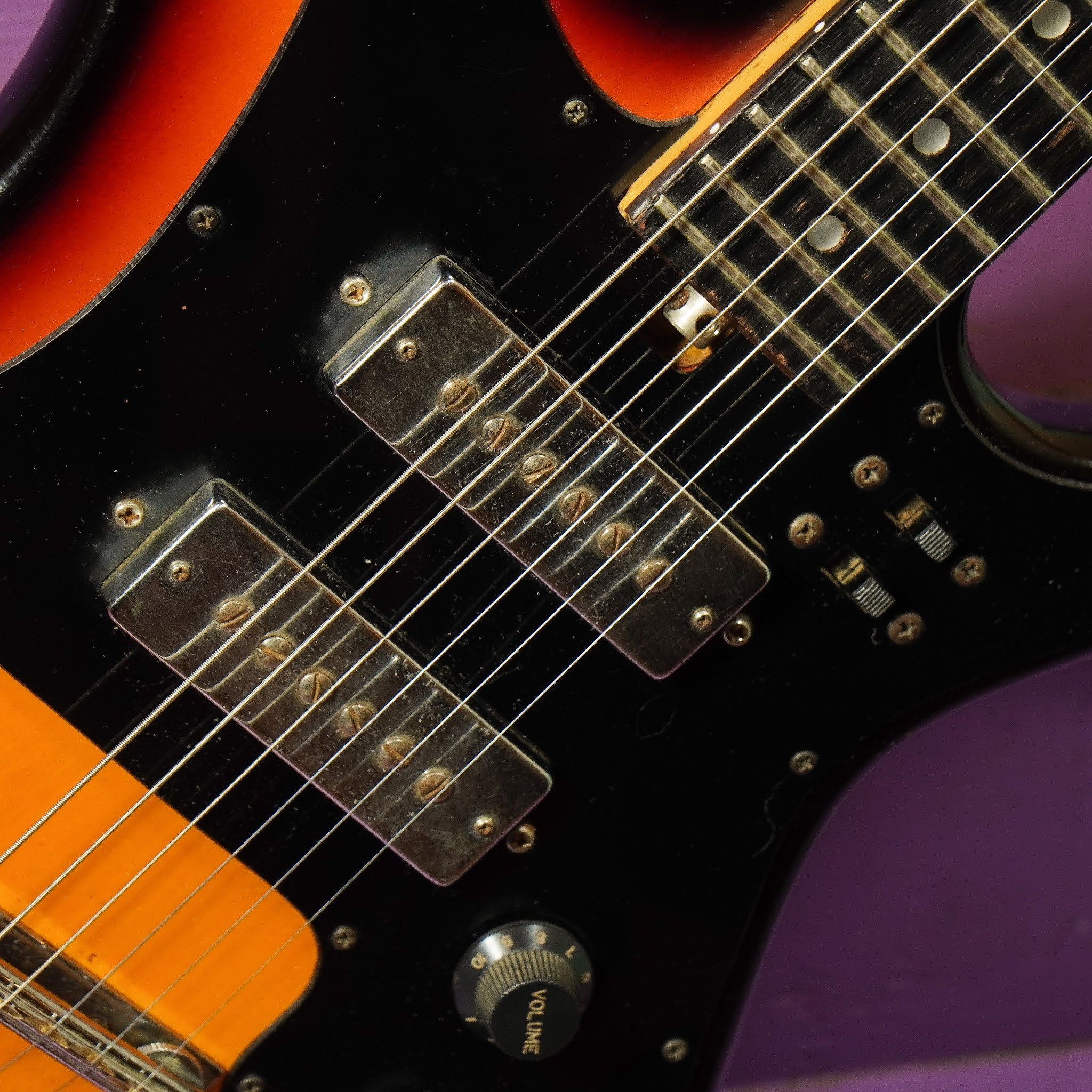 Close-up image showing the guitar's pickups and controls, focusing on the details of the electronics and their configuration.