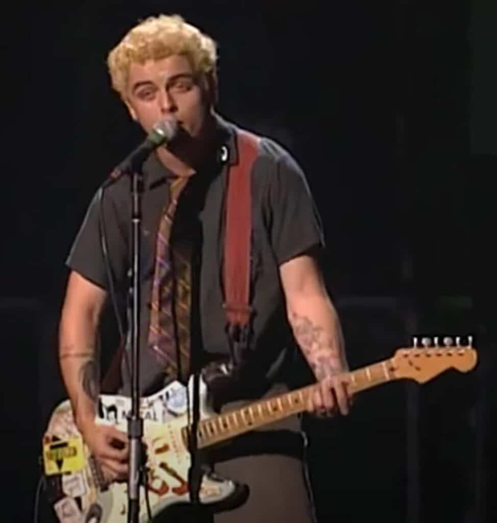 Billie Joe Armstrong in 1994, playing his sticker-covered blue Stratocaster guitar during Green Day's early success.