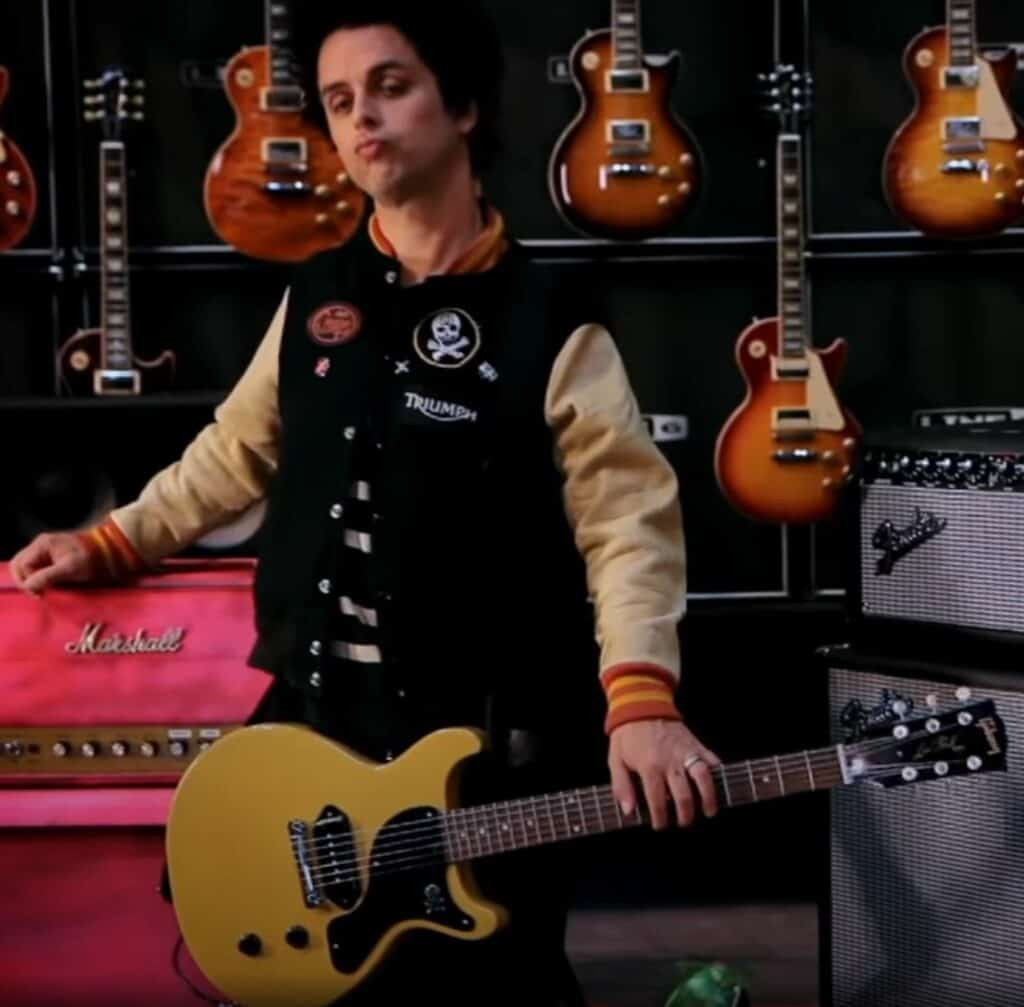 Billie Joe Armstrong playing his signature yellow Gibson Les Paul Junior, showcasing its double-cutaway design.