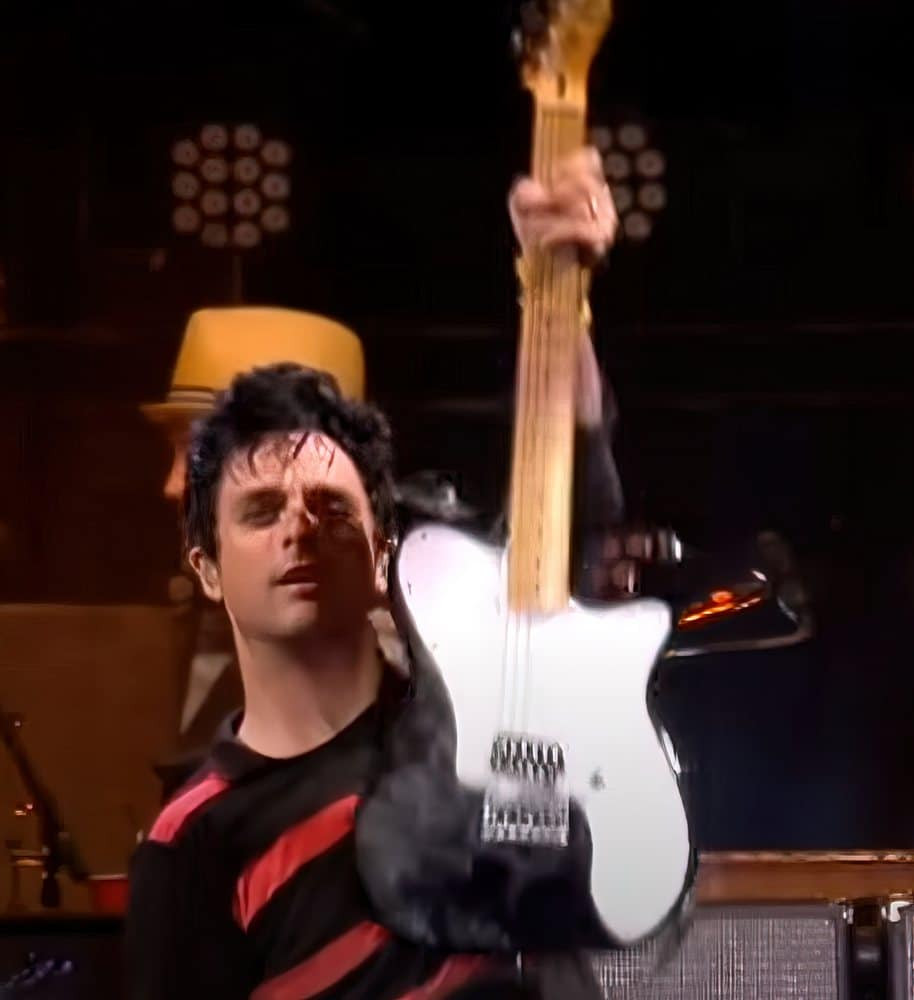 Billie Joe Armstrong holding a black Telecaster guitar at the Reading Festival, showcasing his preference for simple, powerful instruments.