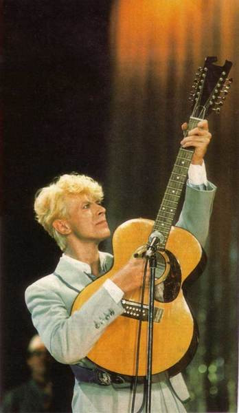 David Bowie in the eighties playing his Ziggy-era Harptone acoustic guitar