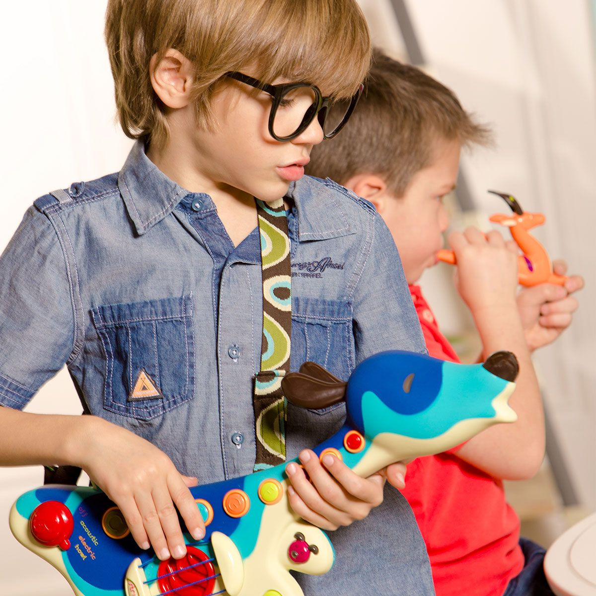 Two toddlers playing together with the Woofer puppy guitar and other musical toys