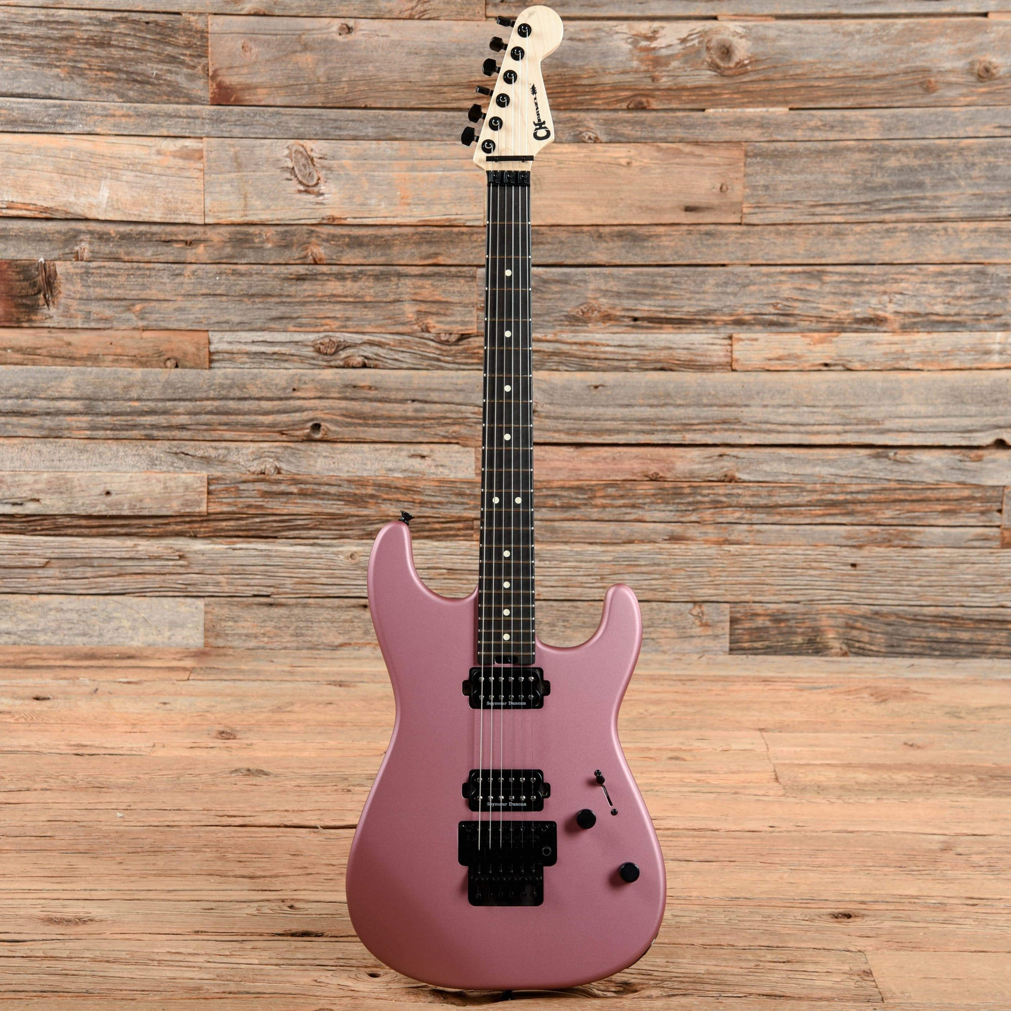 A Charvel San Dimas Superstrat in Burgundy Mist, highlighting its Floyd Rose tremolo and humbucker pickups, designed for high-speed playing