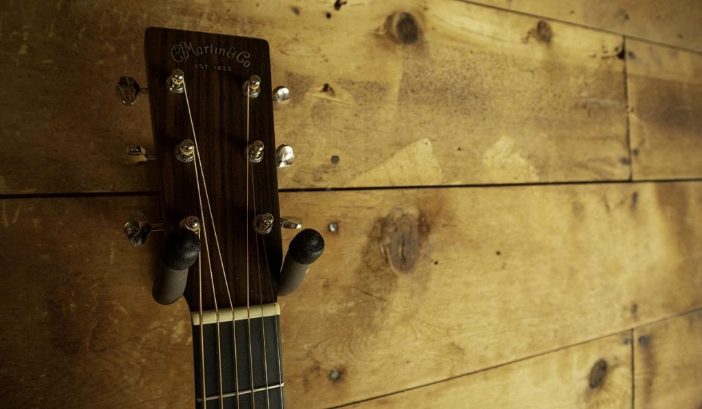 Guitar on a wall hanger in an easily accessible location