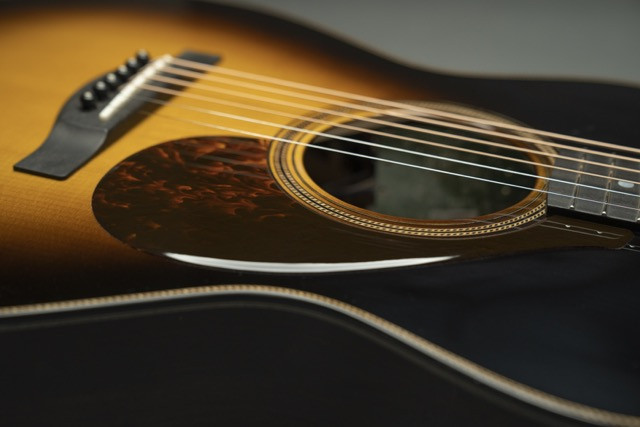 Various angles of the custom Yamaha acoustic guitar, showcasing its tobacco burst finish, body shape, and overall design