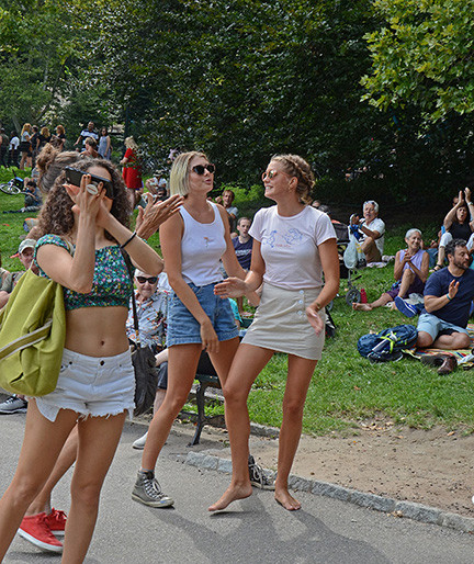 People dancing at a performance, highlighting the joyful and interactive atmosphere