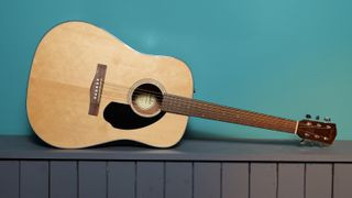 Fender CD60 against a blue wall in our photo studio