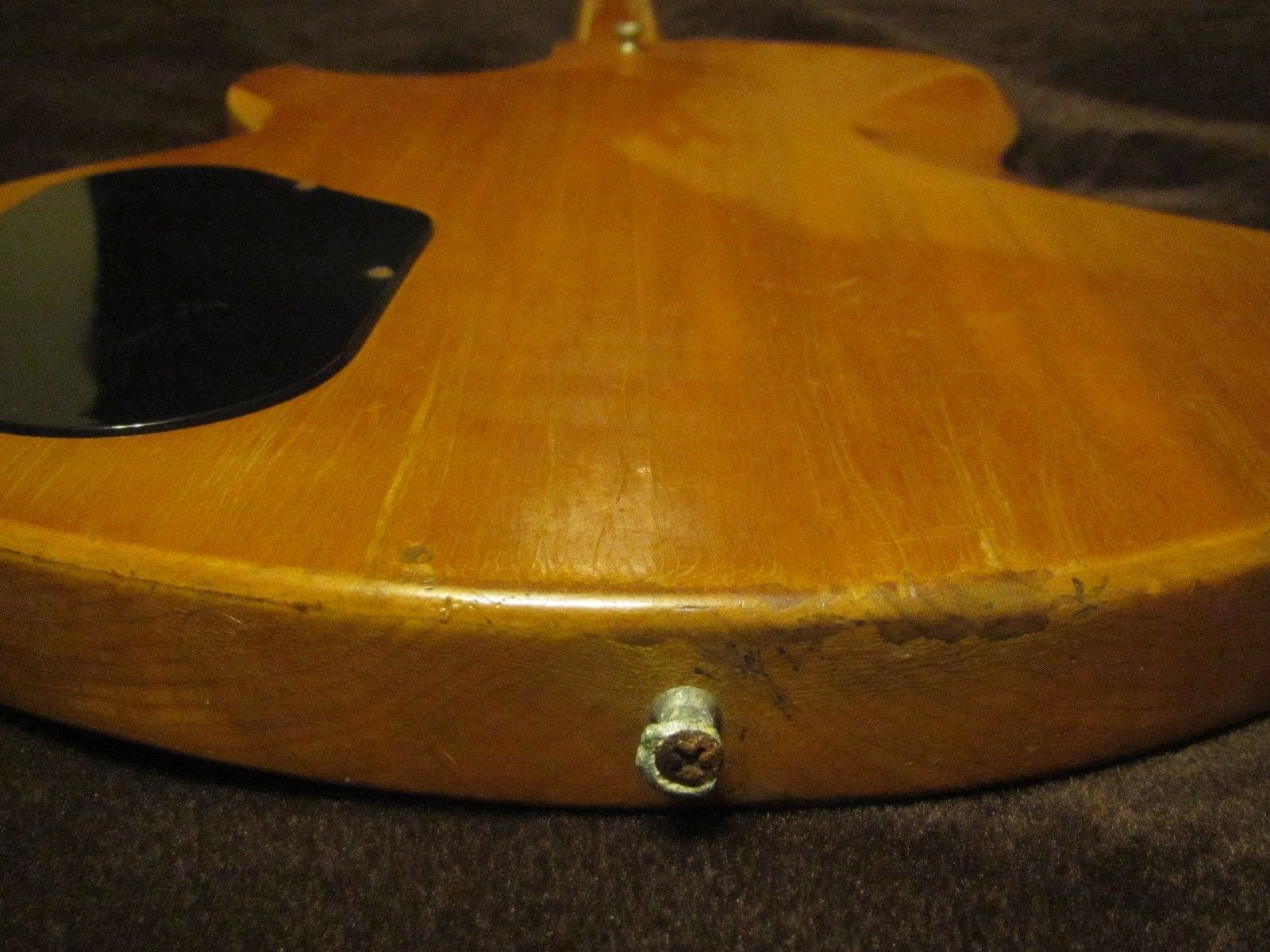 The lower body curve of the Gibson L6-S guitar, showing its solid maple body construction and the strap button placement, features that define its comfortable playability and balanced feel.