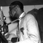 Elmore James playing blues guitar, showcasing his slide technique and electric pickup, circa 1960