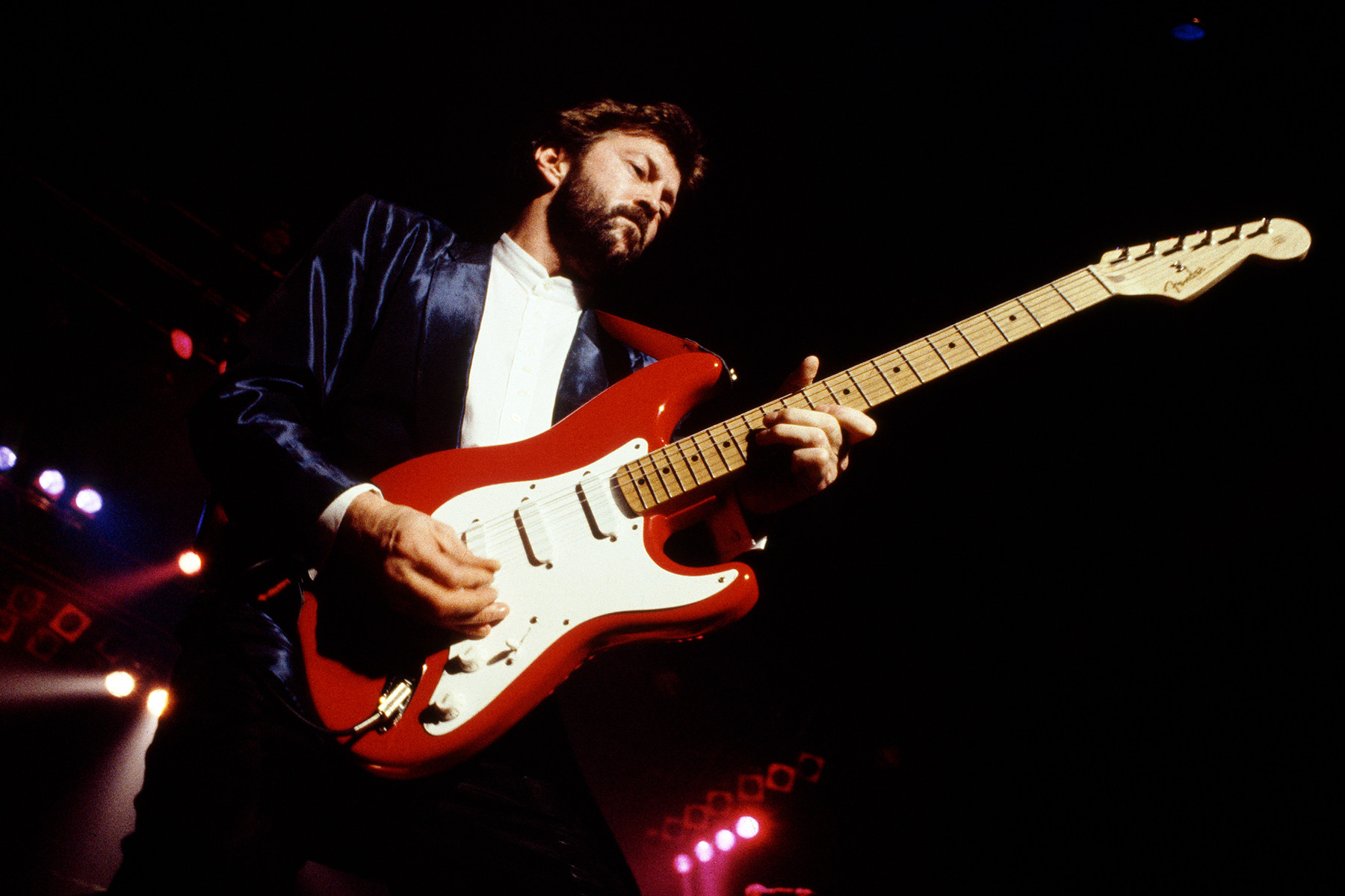 Eric Clapton playing a Fender Stratocaster in Rome, 1986, showcasing his melodic blues-rock guitar style and expressive solos
