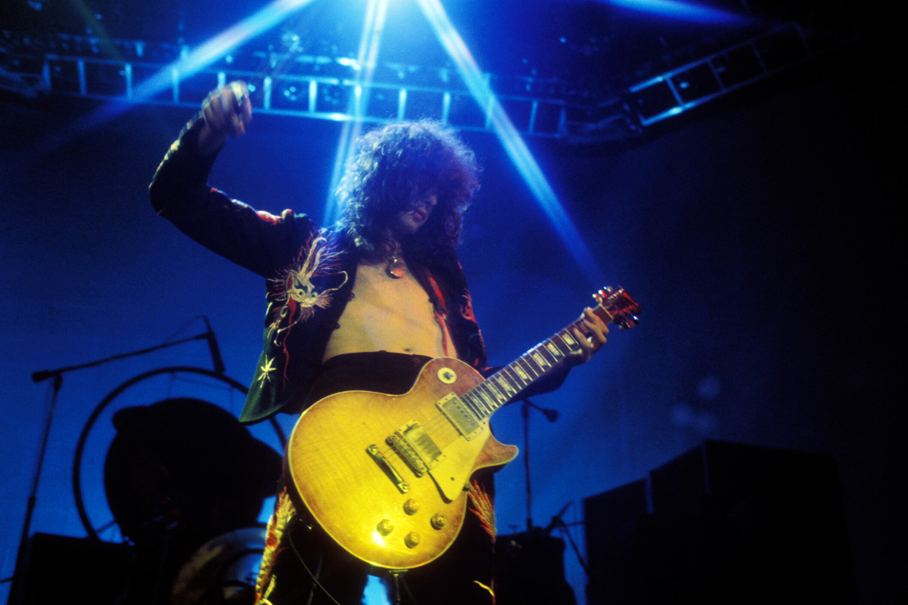 Jimmy Page of Led Zeppelin performing at Earl's Court, showcasing his legendary riffs and his iconic stage presence