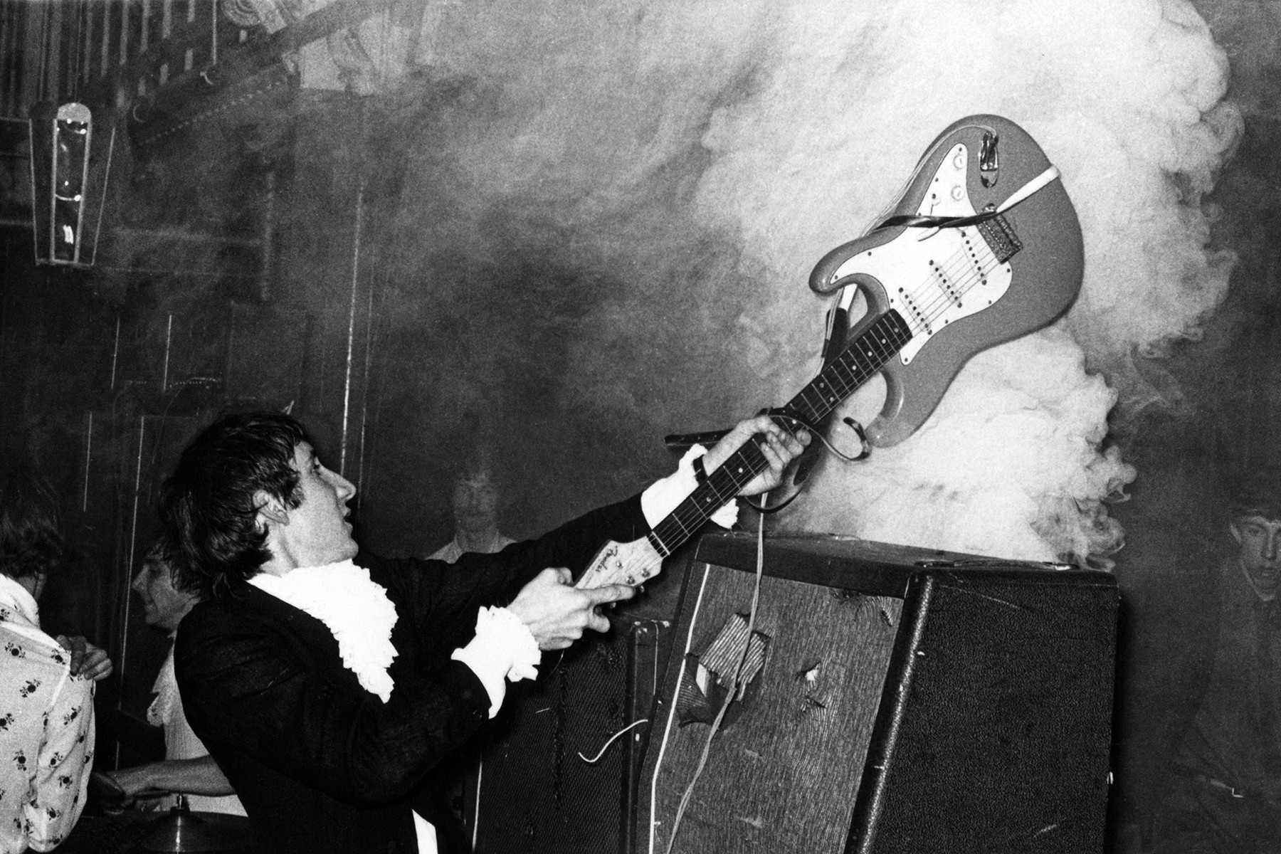 Pete Townshend of The Who smashing his guitar on stage, a symbol of his energetic performances and power chord innovation