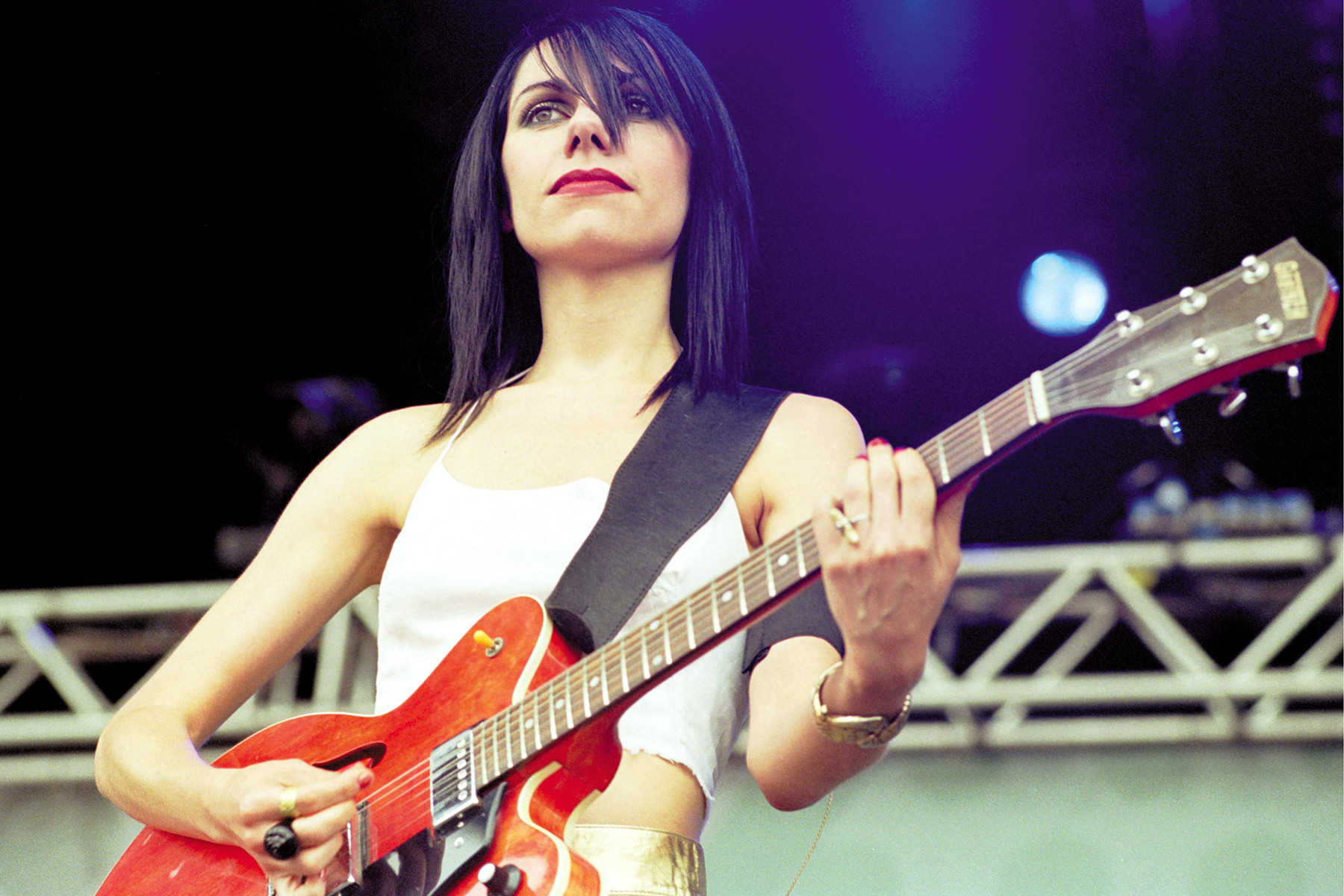 PJ Harvey performing live in Belgium in 2001, wielding her guitar with raw energy and emotion
