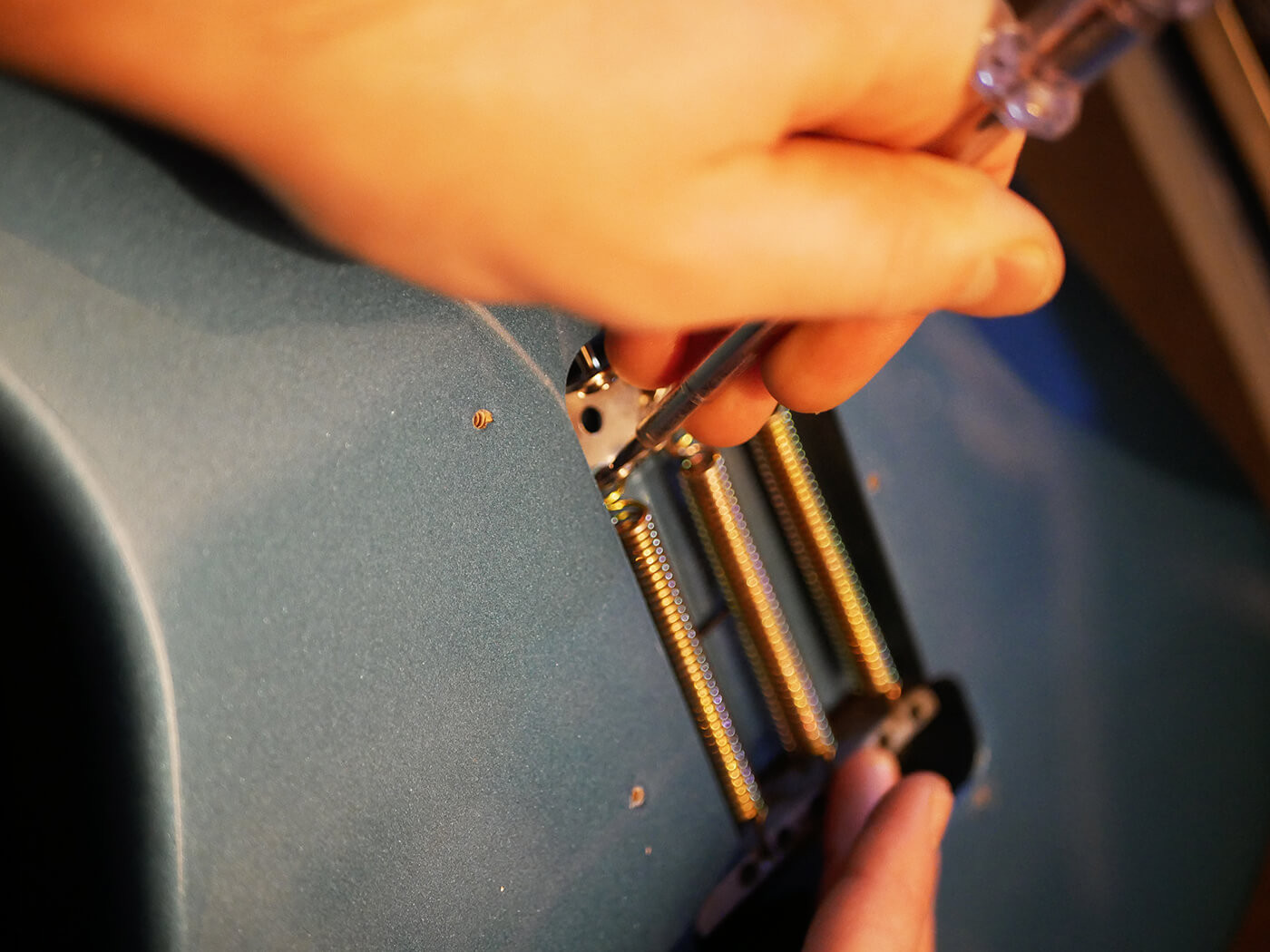 Polishing the guitar body with guitar polish, illustrating the final cleaning step before restringing in the process of how to set up a guitar.
