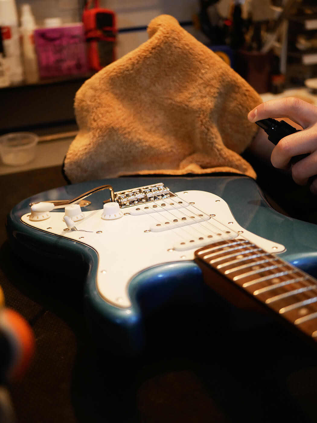 Adjusting the truss rod using an Allen key in the headstock of a guitar, showing the crucial neck relief adjustment step in how to set up a guitar.