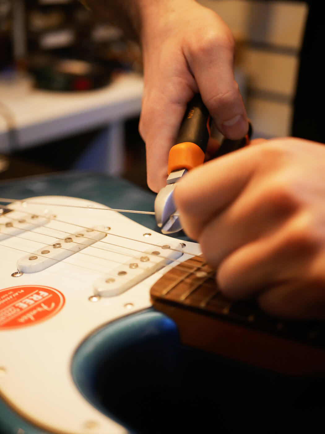 Overhead shot of guitar setup tools and a guitar neck, illustrating the necessary equipment for learning how to set up a guitar.