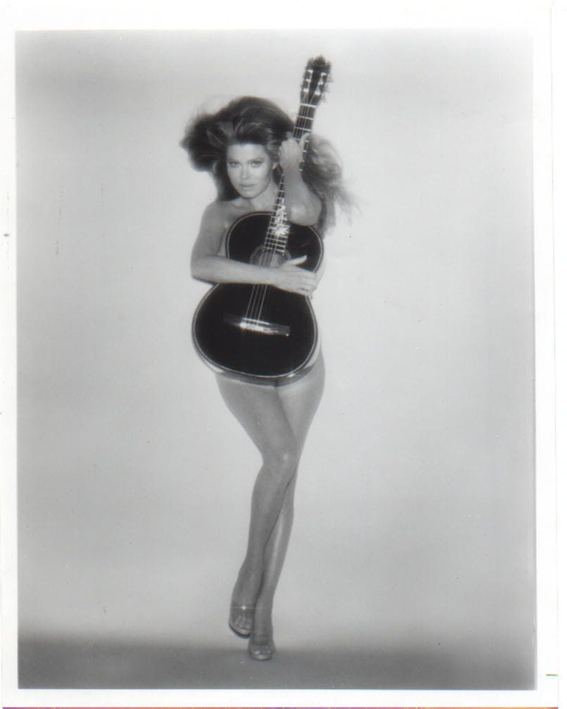 Charo promotional photo 1979 showcasing her holding a classical guitar, highlighting her musical talent beyond her cuchi-cuchi persona.