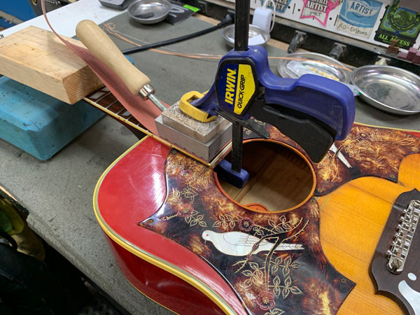 Applying dry heat to the Gibson Dove's neck joint for removal