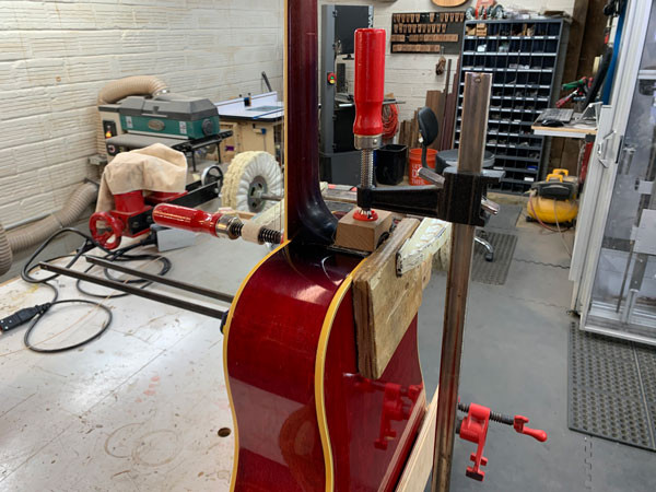 Clamps securing the neck joint during glue drying on the Gibson Dove