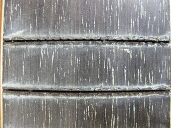 Comparison of a raw fret slot (top) and a cleaned fret slot (bottom) after Dremel treatment