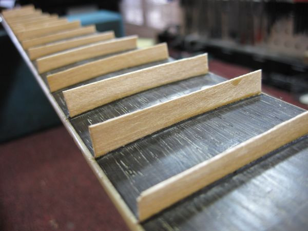 Inserting maple veneer strips into the cleaned fret slots to create fret lines