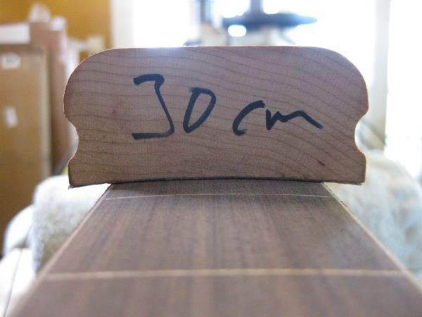 Close-up of the leveling process, showing radius blocks used to maintain the fretboard curvature during sanding