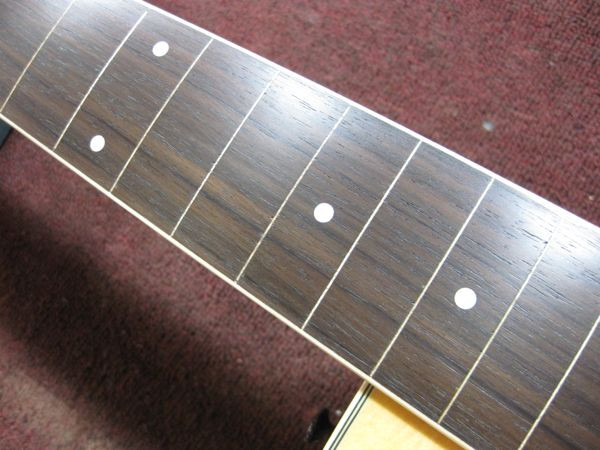 Applying gunstock oil to the leveled fretboard to seal and protect the wood