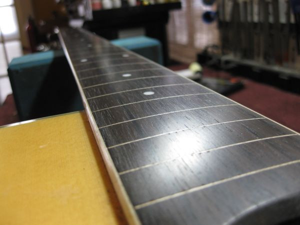 The finished fretless fretboard after oiling, showcasing the enhanced wood grain and smooth surface