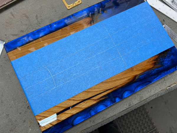 Angled view of the guitar body during the neck pocket routing process, showcasing the initial cuts being made into the epoxy material.