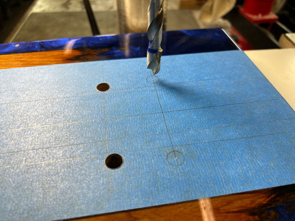 Close-up of the drill press precisely drilling holes for the bridge studs into the prepared guitar body, ensuring correct placement.