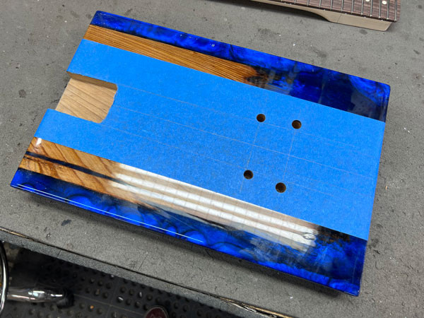 Image showing the bridge stud bushings being installed into the drilled holes in the guitar body, preparing for bridge mounting.