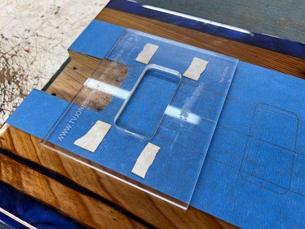Close-up of the pickup cavity routing process in progress, showing the router bit removing material to create space for the pickups.