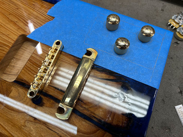 Image showing the planning stage of the electronics layout, with components positioned on the guitar body to determine wiring paths and control placement.
