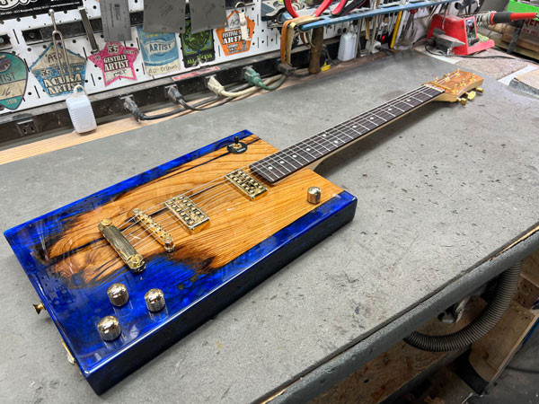 Guitar neck undergoing fret leveling on the Plek machine, ensuring optimal playability and intonation.